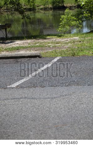 White Line Dividing Parking Spaces In Front Of A Small Pond