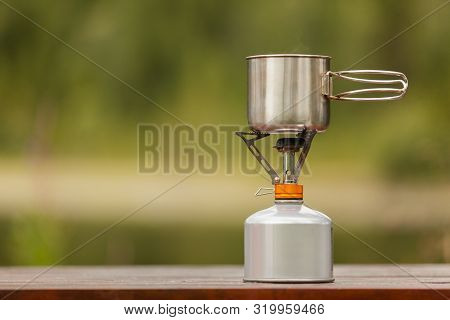 The Camping Iron Mug With A Gas Burner On Background