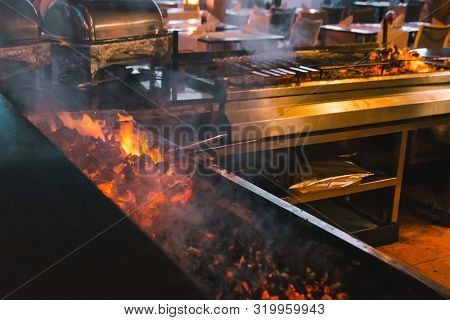 Frying Meat On Fire In Hotel Or Restaurant Kitchen With Smoke Coming Up