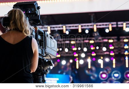 Camerawoman With Professional Video Camera Is Shooting Live Performace.