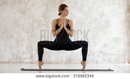 Woman Practicing Yoga, Standing In Goddess Pose, Sumo Squat Exercise