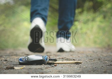 Lost Keys On A Road In Park And Walking Away Female Legs In A Shoes.