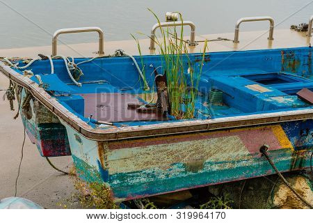Closeup Of Aft Section Of Fishing Boat On Concrete Pier On Rainy Morning.