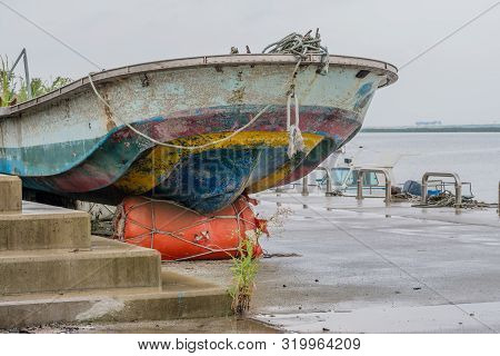 Fore Section Of Fishing Boat Dry Docked On Concrete Pier On Rainy Morning.