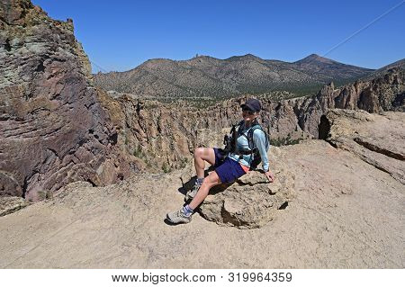 Woman On Misery Ridge Trail In Smith Rock State Park Near Terrebonne, Oregon On A Coudless Summer Da