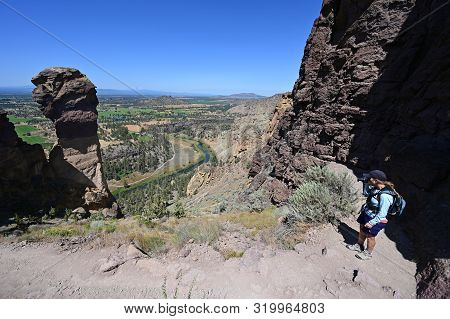 Woman Hikes And Photographs Misery Ridge Trail In Smith Rock State Park Near Terrebonne, Oregon On C