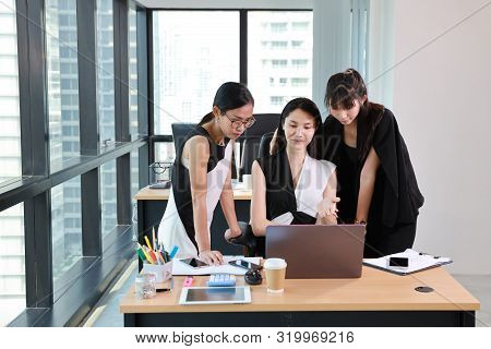 3 Asian Employees Of A Company Are Updating Some Information With Smiling And Laughing Face From Com