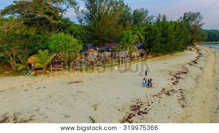Labuan,malaysia-aug 18,2019:aerial View Of Sandy Beach,trees & People In Pohon Batu Beach In Labuan 
