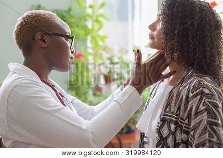 African Female Doctor Watching Patient With Sore Throat