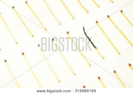 Isolated Lonely Burnt Match In Group With Other Matches