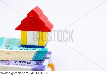 Close Up Of A Small Toy House On Pile Of Bundled Notes And Copy Space At Right For Saving Concept