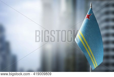 A Small Flag Of Aruba On The Background Of A Blurred Background