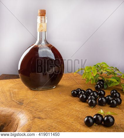 Jaboticaba, Bottle And Glass Of Homemade Brazilian Jaboticaba Liqueur On Wood With Leaves And Branch