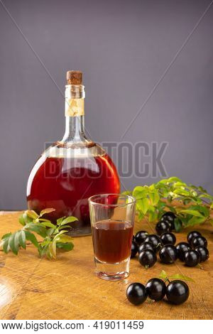 Jaboticaba, Bottle And Glass Of Homemade Brazilian Jaboticaba Liqueur On Wood With Leaves And Branch