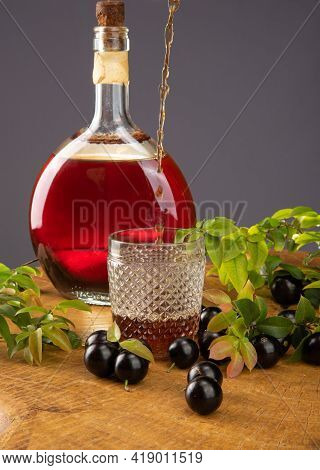 Jaboticaba, Bottle And Glass Of Homemade Brazilian Jaboticaba Liqueur On Wood With Leaves And Branch