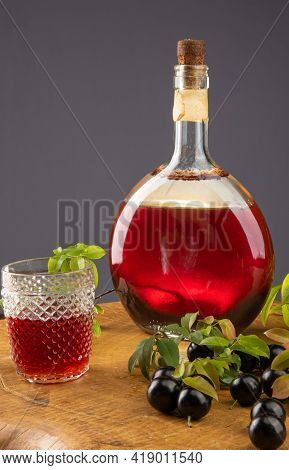 Jaboticaba, Bottle And Glass Of Homemade Brazilian Jaboticaba Liqueur On Wood With Leaves And Branch
