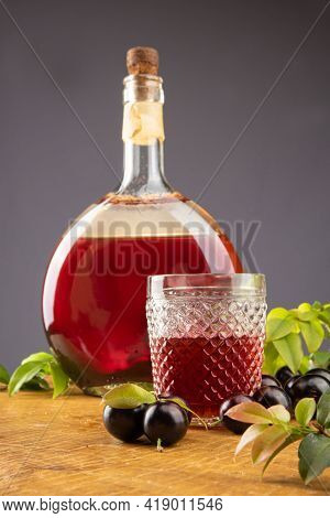 Jaboticaba, Bottle And Glass Of Homemade Brazilian Jaboticaba Liqueur On Wood With Leaves And Branch