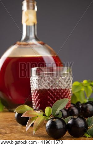 Jaboticaba, Bottle And Glass Of Homemade Brazilian Jaboticaba Liqueur On Wood With Leaves And Branch