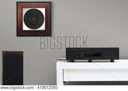 Hifi System Amplifier And Floor Acoustics. Framed Vinyl On The Wall.