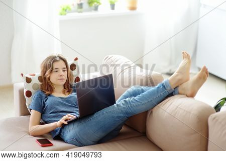 Woman Working With Laptop Computer Lying On Sofa At Home. Freelancer Or Blogger. Distance Learning. 