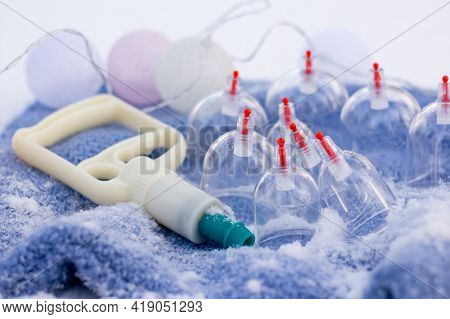 Jars For Hijama On A Knitted Blue Plaid In The Snow In The Forest. Vacuum Therapy. Bloodletting Acco