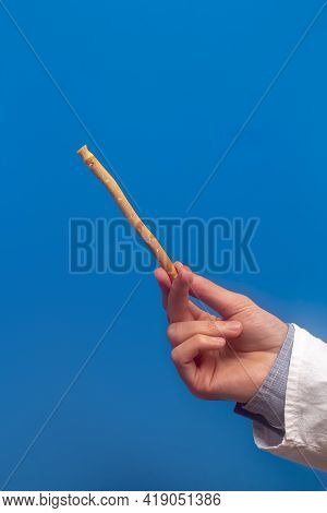 Guy Hold Miswak On Blue Background. Teeth Cleaning. Sunnah Teeth Brushing. Sivak