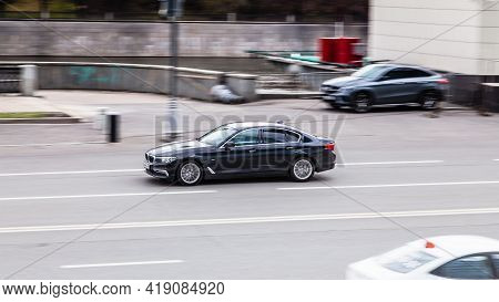 Black Color Bmw 5 Series In Fast Motion On City Street. Speeding In The City Is Not Permissible. Mos