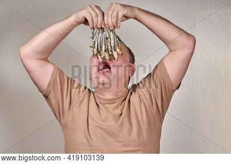 A Man Holds In His Hands A Lot Of Fish Gnawed To The Bone