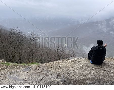 Guamka, Russia April 17, 2021: Tourists On Huge Cliff With Spectacular View Of Nature. Group Of Peop
