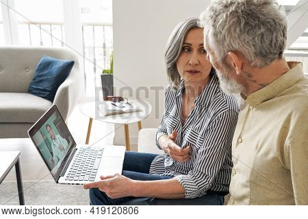 Mature Old Grandparents Couple Patients Having Video Chat With Virtual Doctor Using Laptop Computer 