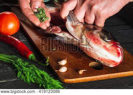 Cook Or Chef Prepares Fresh Fish Bighead Carp With Add Spice. Preparing To Cook Fish Food. Working E