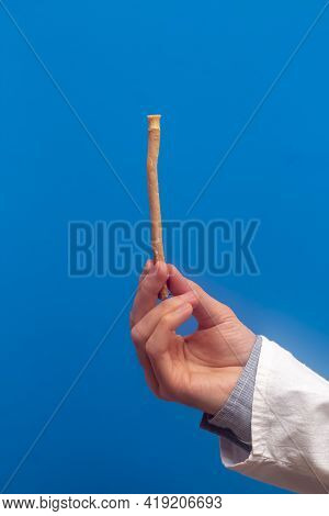 Guy Hold Miswak On Blue Background. Teeth Cleaning. Sunnah Teeth Brushing. Sivak.