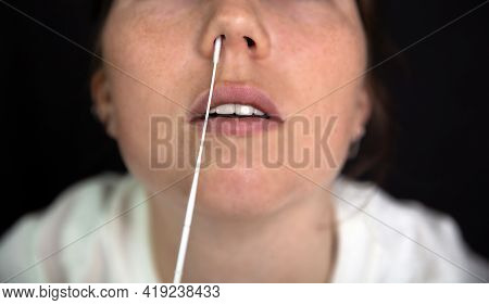 Young Woman Taking A Covid-19 Sars-cov-2 Test During Corona Pandemic On Dark Black Background, Quick