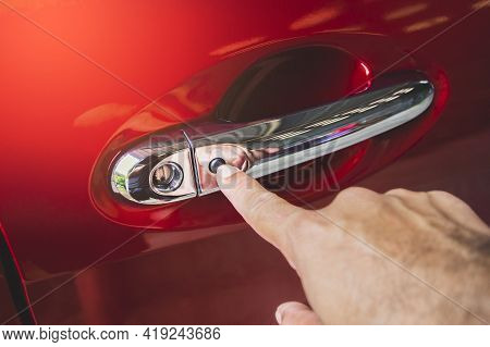 Human Hand Was Pressing To Keyless Entry Button On The Car Door Handle Of The Red Car