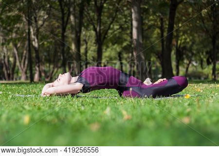 Slender Young Attractive Blond Girl Practice Yoga Fish Pose In Summer Sunny Park