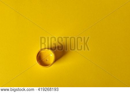 A Jar Of Yellow Gouache Stands On A Yellow Background