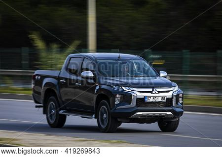 Alanya, Turkey - April 16 2021:   Black Mitsubishi L200 Is Driving Fast On The Street On A Warm Summ