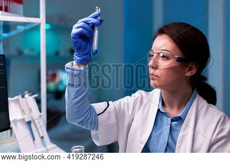 Scientist Looking At Testube With Sample, Analyzing Liquid Experiment