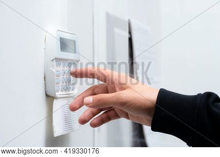 Hand Entering Alarm System Password Of An Apartment, Home Or Business Office. Surveillance And Prote