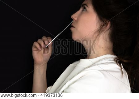 Young Woman Taking A Covid-19 Sars-cov-2 Test During Corona Pandemic On Dark Black Background, Quick