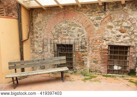 Courtyard In The Old Medieval Town. A Courtyard With An Old Shop In Barga. A Resting Place Near One 