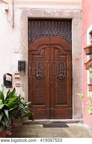 Beautiful Front Door. Carved Door With Metal Forging. Entrance To One Of The Old Houses In Barga.