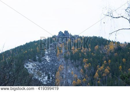 Mountain In The Autumn Forest With Trees With A Stone Rock At The Top.