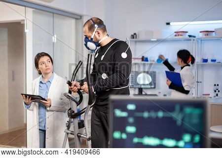 Sport Scientist Monitoring Performance Of Athlete Cardio