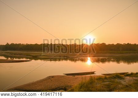 Sunset In The River And Boats On The Shore