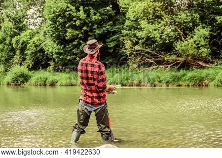 Hobby And Sport Activity. Pothunter. Fisherman With Fishing Rod. Mature Man Fly Fishing. Man Catchin