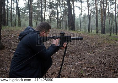 Man with KRISS Vector 9*21 caliber submachine gun in the forest. Unformal shooting range near Kiev. April 30,2021. Kiev Region, Ukraine