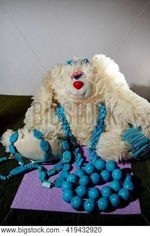 Beautiful Blue Beads And Funny Rabbit On A Green Surface
