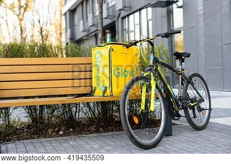 Kiev, Ukraine - April 28, 2021: Glovo Bike Courier On The Street. Delivery Boy Of Glovo Delivery Ser
