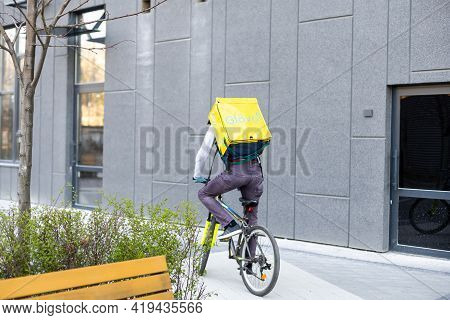Kiev, Ukraine - April 28, 2021: Glovo Bike Courier On The Street. Delivery Boy Of Glovo Delivery Ser